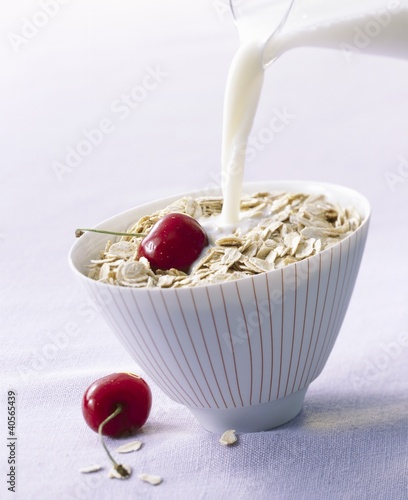 Foto: Pouring milk onto oat flakes Pouring milk onto oat flakes