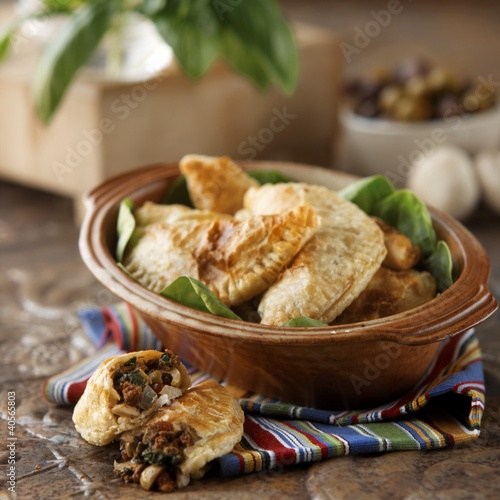 Photo: Empanadas Served in a Ceramic Crock; One Broken in Half Empanadas Served in a Ceramic Crock; One Broken in Half
