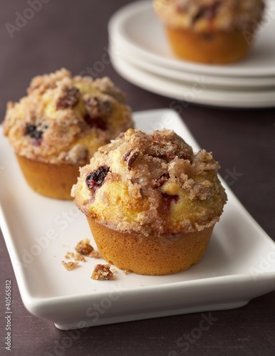 Foto: Three blackberry and raspberry muffins on plates Three blackberry and raspberry muffins on plates