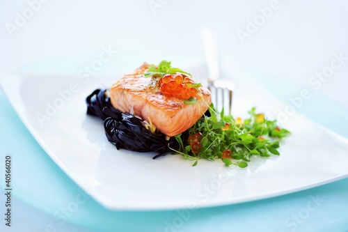 Photo: Fried salmon on black tagliatelle with baby basil Fried salmon on black tagliatelle with baby basil