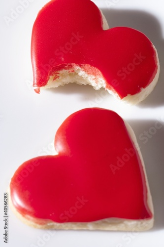 Foto: Red heart-shaped biscuits, whole and partly eaten Red heart-shaped biscuits, whole and partly eaten
