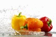 Peppers (yellow, orange, red) with splashing water