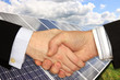 Businessmen shaking hands in front of Solar Power Station