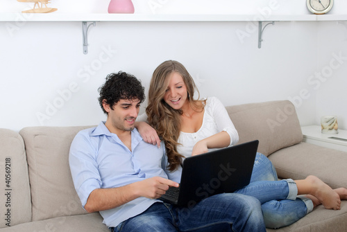 Photo: Young couple watching something on a laptop Young couple watching something on a laptop