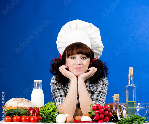 Foto: Smiling happy cook woman with food ingredients Smiling happy cook woman with food ingredients
