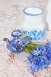 bluebel, vase and teapot on a lace tablecloth, still life