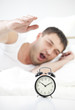 Foto: Sleeping man reaching for alarm clock Sleeping man reaching for alarm clock
