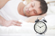 Foto: Man sleeping with alarm clock Man sleeping with alarm clock
