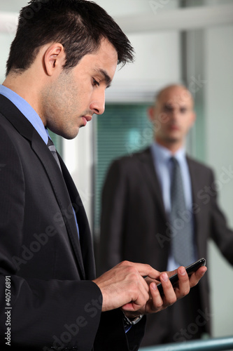 Photo: Businessman sending a text message Businessman sending a text message