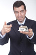 businessman with a small house in his hand