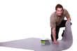 Man putting down linoleum flooring