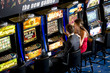 Photo: Young couple playing with slot machines Young couple playing with slot machines
