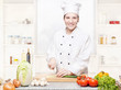 female chef cutting onions on the cutting board in kitchen