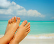 Vacation Concept. Woman's Bare Feet over Sea background Vacation Concept. Woman's Bare Feet over Sea background