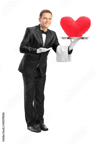 Photo: Butler holding a tray with a red heart shape on it Butler holding a tray with a red heart shape on it