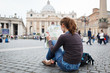 Photo: Pretty young female tourist studying a map at St. Peter's square Pretty young female tourist studying a map at St. Peter's square