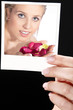 Hand zeigt Foto mit SPA Beauty Frau und Blütenblätter