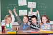 vier schulkinder zeigen auf