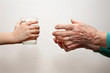 hands of grandmother and grandchild with the glass of water hands of grandmother and grandchild with the glass of water