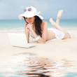 Cute woman with white laptop on the summer beach