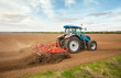 Small scale farming with tractor and plow in field