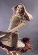 The young brunette тацует in a long dress