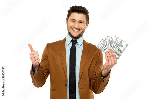 Photo: Man with dollar bills showing thumbs up Man with dollar bills showing thumbs up