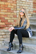Smiling young girl sitting on the stairs in sunglasses Smiling young girl sitting on the stairs in sunglasses