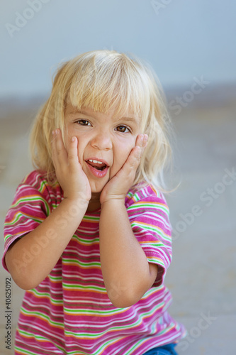 Photo: little girl in striped dress poses faces little girl in striped dress poses faces