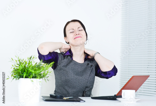 Photo: Business woman with pain in her neck Business woman with pain in her neck