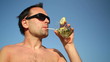 Young man having a drink against blue sky