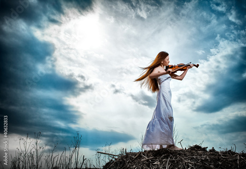 Photo: The red-haired girl with a violin outdoor The red-haired girl with a violin outdoor