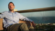 Happy young man relaxing on luxury hotel terrace