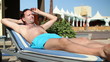 Handsome man sunbathing on sunbed by the pool