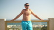 Portrait of young man sunbathing on luxury hotel terrace