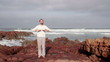 Man doing breathing exercises on Legzira beach