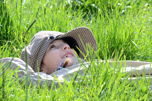 Foto: Kind in der Wiese blickt nach oben Kind in der Wiese blickt nach oben