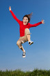 Girl jumping, running against blue sky