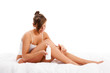 Woman massaging legs sitting on white background