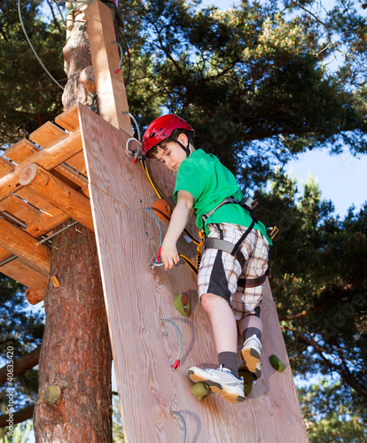 Photo: Boy climbing in adventure park Boy climbing in adventure park