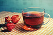 Cup of tea and physalis on a bamboo table cloth still life