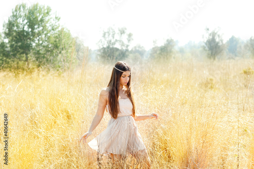Foto: Asian indian woman walking in golden dried field Asian indian woman walking in golden dried field