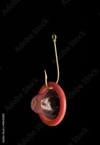 Photo: red condom and fishing hook red condom and fishing hook