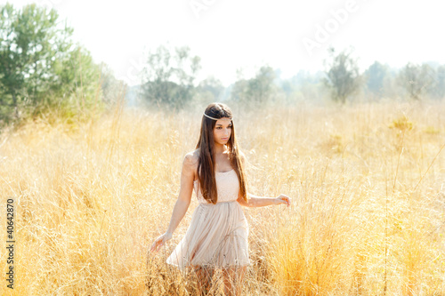 Foto: Asian indian woman walking in golden dried field Asian indian woman walking in golden dried field