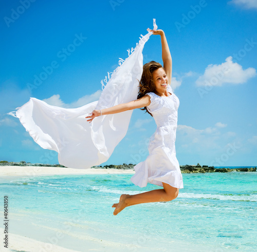 Foto: Beautiful Girl With White Scarf Jumping on The Beach Beautiful Girl With White Scarf Jumping on The Beach