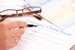 hand filling in insurance claim form