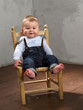 Lachender kleiner Junge sitzt auf einem Stuhl Lachender kleiner Junge sitzt auf einem Stuhl