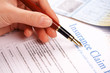 hand filling in insurance claim form