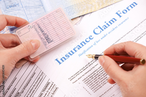 Photo: hand filling in insurance claim form hand filling in insurance claim form