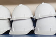 Stack of white plastic safety helmets on table
